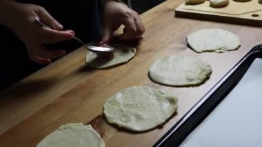 female hands put minced filling in puff pastry, homemade food, samsa making, traditionally