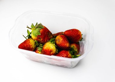 Beyaz arka planda bir kasede taze çilek.