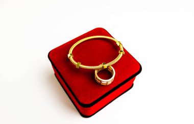 gold ring with red heart on white background