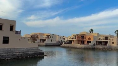 Gündüz vakti mavi gökyüzü olan palmiye ağaçları olan bir villa.