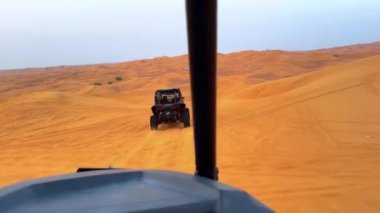Dubai yakınlarındaki çölde dört tekerli bisiklet turu. ATVSand ve Sand Borkhan 'daki çöl off-road maceraları. Kaya ve gün batımı. Dörtlü Bisiklet Seyahati. İnsanlarla bir gezi. Yüksek kaliteli FullHD görüntüler