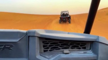 Dubait yakınlarındaki çölde dörtlü bisiklet sürme. ATV ve Sand Borkhan 'daki çöl off-road maceraları. Kaya ve gün batımı. Dörtlü Bisiklet Seyahati. İnsanlarla bir gezi. Yüksek kaliteli FullHD görüntüler