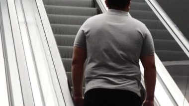Yürüyen merdivenden çıkan adam dikiz aynasından bakıyor. Yüksek kalite 4k görüntü