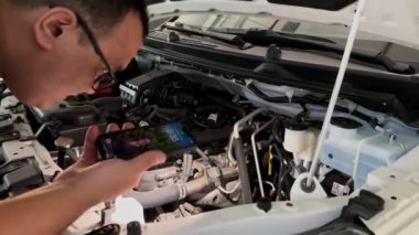 Adam kaputun altındaki arabayı kontrol ediyor. Yüksek kalite 4k görüntü