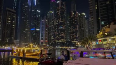 Gece Dubai Marina yürüyüş alanı, yüksek binalar geceleri aydınlık. Yüksek kalite 4k görüntü
