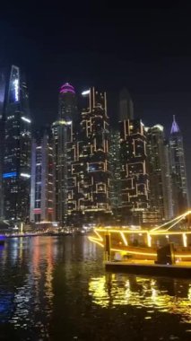 Gece Dubai Marina yürüyüş alanı, yüksek binalar geceleri aydınlık. Yüksek kalite 4k görüntü