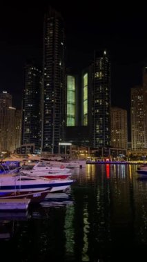 Gece Dubai Marina yürüyüş alanı, yüksek binalar geceleri aydınlık. Yüksek kalite 4k görüntü