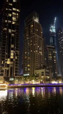 Gece Dubai Marina yürüyüş alanı, yüksek binalar geceleri aydınlık. Yüksek kalite 4k görüntü