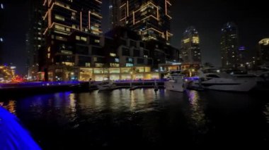 Gece Dubai Marina yürüyüş alanı, yüksek binalar geceleri aydınlık. Yüksek kalite 4k görüntü