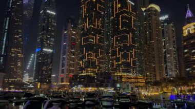 Gece Dubai Marina yürüyüş alanı, yüksek binalar geceleri aydınlık. Yüksek kalite 4k görüntü