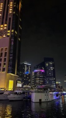 Gece Dubai Marina yürüyüş alanı, yüksek binalar geceleri aydınlık. Yüksek kalite 4k görüntü