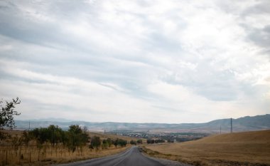 Bulutlu bir gökyüzü ile bir tarlada yol
