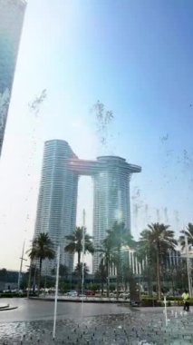 Şehir çeşmesi, gündüz manzarası, binalar arasında güneş ışığı, şehirdeki yüksek binalar.