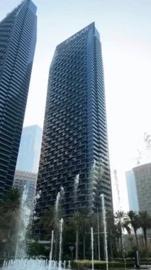 Şehir çeşmesi, gündüz manzarası, binalar arasında güneş ışığı, şehirdeki yüksek binalar.