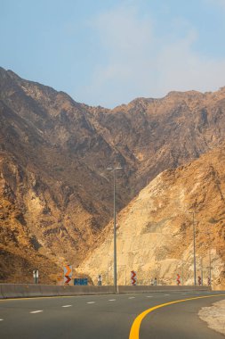 Fujairah dağları, Omani Al Hajar dağ sırasının uzantısı. Boş sokakta bulutlu bir kış günü. Yüksek kalite fotoğraf