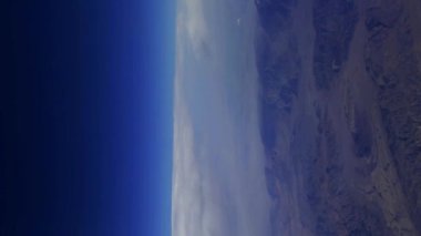 Dağ manzarasının üstündeki kanadın üstündeki uçak penceresinden manzara. Yüksek kalite 4k görüntü