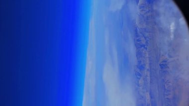 Dağ manzarasının üstündeki kanadın üstündeki uçak penceresinden manzara. Yüksek kalite 4k görüntü