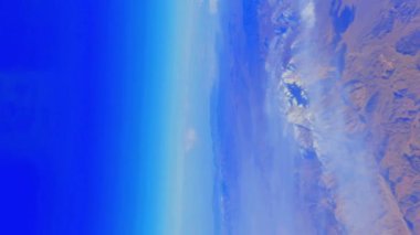 Dağ manzarasının üstündeki kanadın üstündeki uçak penceresinden manzara. Yüksek kalite 4k görüntü