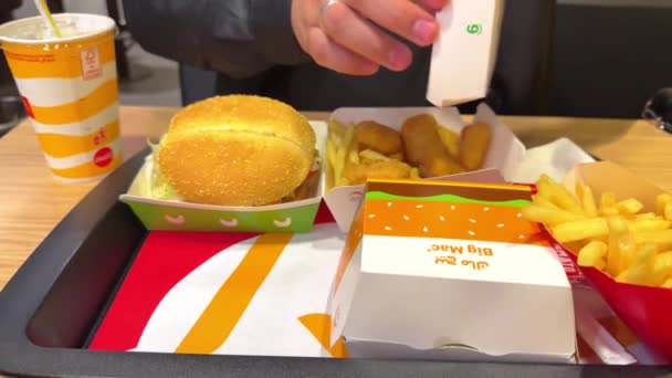 餐桌上摆满了麦当劳餐厅里的快餐 一家人都在吃着不健康的快餐 有麦当劳标志盒的巨无霸薯条 — 图库视频影像