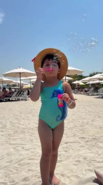 Kumsalda mayo giymiş küçük tatlı kız.