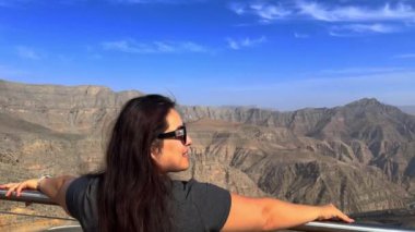 Dağ manzarasının arka planındaki kız