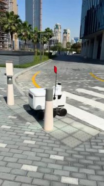 Şehir Caddesinde Otomatik Teslimat Robot Servisi Sürücüsü. Modern Akıllı Kablosuz Robot bir müşteriye yiyecek ya da yiyecek dağıtıyor. Onli 'nin Yeni Teknolojik Çok İş Endüstrisi Teslimat Lojistiği. Yüksek kalite 4k görüntü