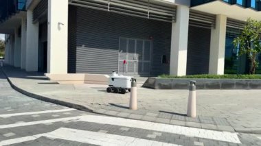 Şehir Caddesinde Otomatik Teslimat Robot Servisi Sürücüsü. Modern Akıllı Kablosuz Robot bir müşteriye yiyecek ya da yiyecek dağıtıyor. Onli 'nin Yeni Teknolojik Çok İş Endüstrisi Teslimat Lojistiği. Yüksek kalite 4k görüntü