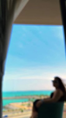 Deniz manzaralı ve pencereli bir kadının bulanık arkaplanı