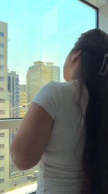 Camları siliyorum. Evde temizlik hizmeti. Sabun solüsyonu pencereye sıçradı. Temiz cam. Camları silmek için kazıyıcı. Ev hanımı pencereyi temizler. Yatay video. Yüksek kalite 4k görüntü