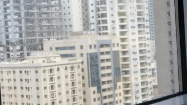 Camları siliyorum. Evde temizlik hizmeti. Sabun solüsyonu pencereye sıçradı. Temiz cam. Camları silmek için kazıyıcı. Ev hanımı pencereyi temizler. Yatay video. Yüksek kalite 4k görüntü