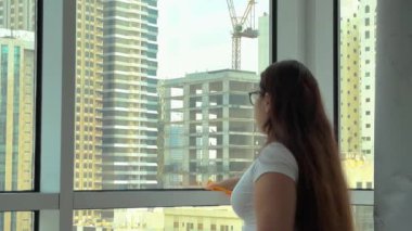 Camları siliyorum. Evde temizlik hizmeti. Sabun solüsyonu pencereye sıçradı. Temiz cam. Camları silmek için kazıyıcı. Ev hanımı pencereyi temizler. Yatay video. Yüksek kalite 4k görüntü