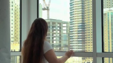 Camları siliyorum. Evde temizlik hizmeti. Sabun solüsyonu pencereye sıçradı. Temiz cam. Camları silmek için kazıyıcı. Ev hanımı pencereyi temizler. Yatay video. Yüksek kalite 4k görüntü