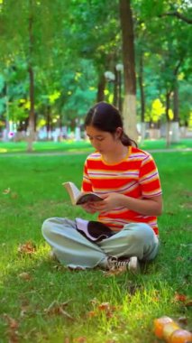 Parkta kitap okuyan güzel bir genç kız.