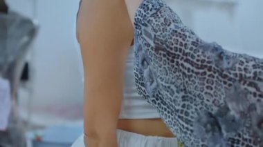 Bir atölyede müşterisi olan bir terzi, bir santimetre bant takıyor, koltuk altı ölçüsünü alıyor, deniyor. Kadın elleri kızların ölçülerini geri alır. Uygun atölye, profesyonel terzi. A