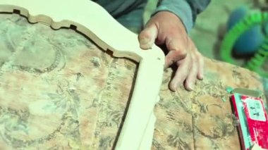 Bir marangoz bir el testeresiyle tahtayı testereyle keser. Katı ahşap mobilya yapmak için bir atölyede tahta işleme süreci. Tecrübeli bir marangoz otantik bir atölyede.