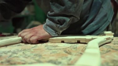 Bir marangoz bir el testeresiyle tahtayı testereyle keser. Katı ahşap mobilya yapmak için bir atölyede tahta işleme süreci. Tecrübeli bir marangoz otantik bir atölyede.