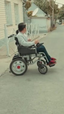 Tekerlekli sandalyedeki yaşlı bayan oturma odasında televizyon izliyor elinde uzaktan kumandalı televizyon kanalı değiştiriyor. Büyükannem televizyonu açıyor. Yüksek kalite 4k görüntü
