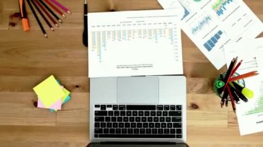 Tahta masaüstünde grafikleri olan dizüstü bilgisayar ve kalem