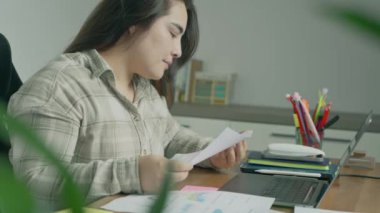 Geceleri ofiste çalışan genç bir kadın..