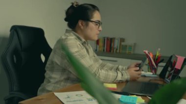 Asyalı iş kadını ofiste çalışıyor. Bilgisayarda çalışıyordu..