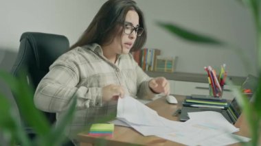 Ofisteki dizüstü bilgisayarda çalışan genç kadın.
