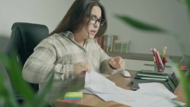 Genç iş kadını ofiste çalışırken bilgisayarla çalışıyor.