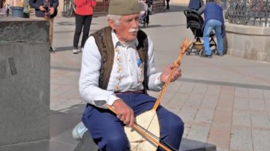 Novi Sad, Sırbistan - 10162024: Gündüzleri kalabalık bir sokakta sokak müzisyenleri çalıyor. Yüksek kalite 4k görüntü