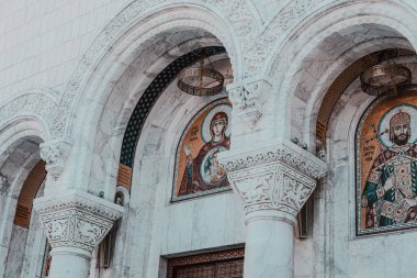 Belgrad, Sırbistan - 10162024: Saint Sava Tapınağı 'nın iç mekanları, insanlar bir Ortodoks kilisesinde, kilisenin tavanı ve duvarlarında freskler görüyor. Yüksek kalite fotoğraf