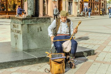 Yaşlı adam gitar çalıyor.