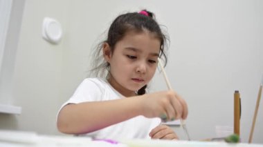 Tuval üzerinde resim yapan Asyalı küçük kız.