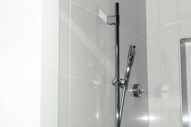 Modern krom çift duş başlığı sistemi. Parlak mermer döşemeli banyo duvarına, ayarlanabilir el bilgisayarı spreyi monte edilmiş. Yüksek kalite fotoğraf