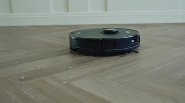 Yuvarlak robot süpürgesi banyoda düzenli olarak hareket ediyor, sensörleri toz ve saç taraması yapıyor. Yüksek kalite 4k görüntü