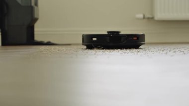 Yuvarlak robot süpürgesi banyoda düzenli olarak hareket ediyor, sensörleri toz ve saç taraması yapıyor. Yüksek kalite 4k görüntü