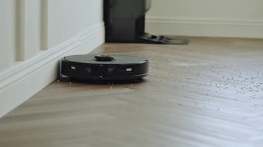 Yuvarlak robot süpürgesi banyoda düzenli olarak hareket ediyor, sensörleri toz ve saç taraması yapıyor. Yüksek kalite 4k görüntü